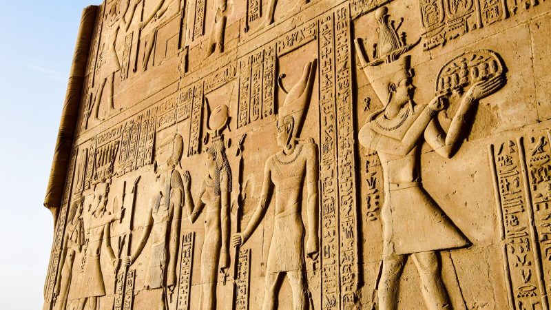 Detailed view of ancient Egyptian hieroglyphs and figures on a temple wall.