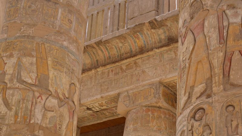 Detailed view of ancient hieroglyphs on the columns of Luxor Temple in Egypt, showcasing historical art.