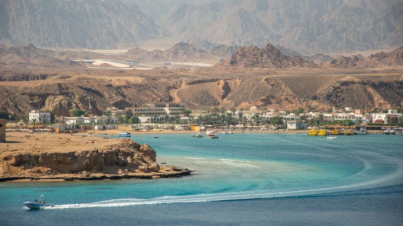 Aerial view of Sharm El Sheikh coastline with turquoise sea and mountainous backdrop.