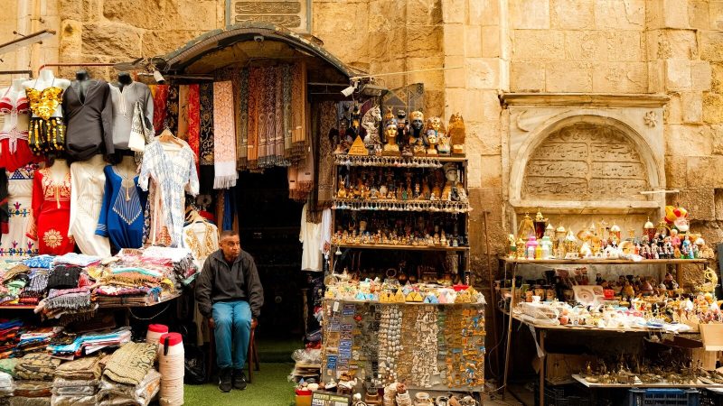Colorful outdoor market stall with traditional souvenirs and clothing. Captures local culture and commerce.