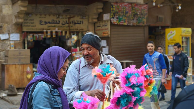 People interacting at a lively market in Cairo, displaying cultural diversity and vibrant street life.