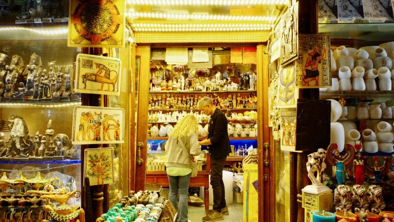 Tourists browse a vibrant souvenir shop in Cairo filled with Egyptian artifacts.