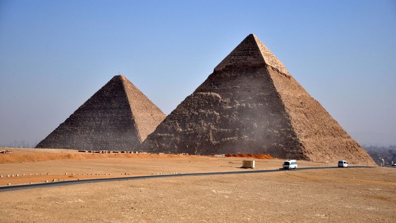 Iconic pyramids of Giza standing under a clear blue sky, showcasing ancient Egyptian architecture.