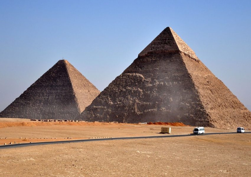 Iconic pyramids of Giza standing under a clear blue sky, showcasing ancient Egyptian architecture.