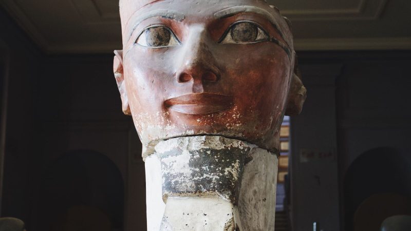 Close-up of an ancient Egyptian sculpture in a museum gallery, showcasing intricate details and historical significance.