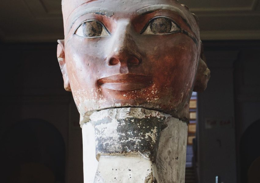 Close-up of an ancient Egyptian sculpture in a museum gallery, showcasing intricate details and historical significance.