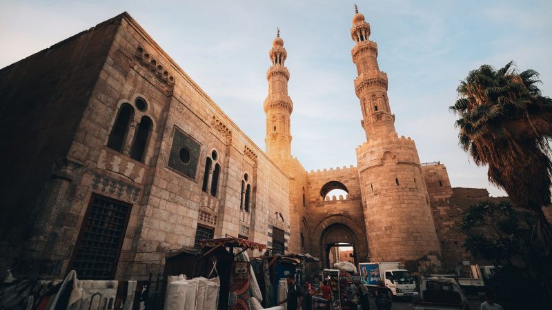 A bustling scene at Bab Zuweila in historic Cairo featuring Islamic architecture and vibrant market life.