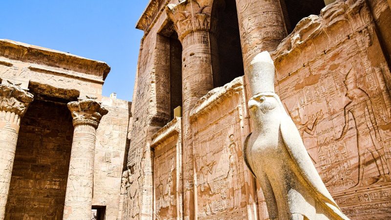 Explore the stunning ruins of an ancient Egyptian temple featuring iconic columns and a falcon statue.