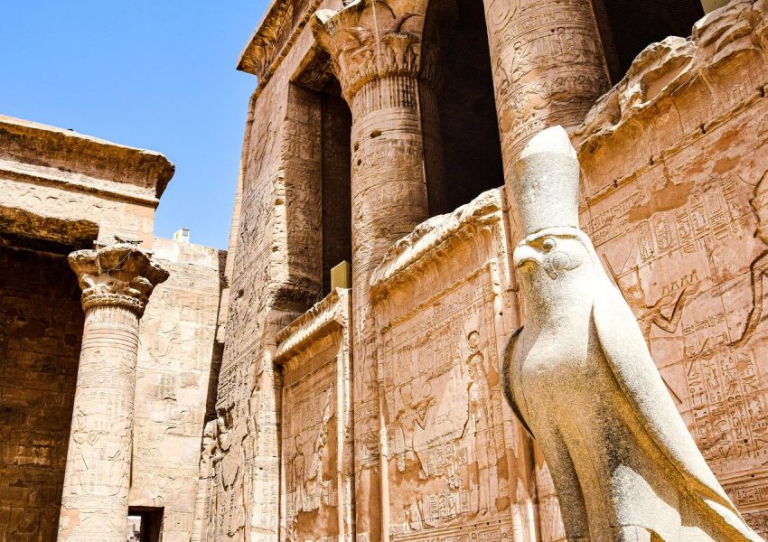 Explore the stunning ruins of an ancient Egyptian temple featuring iconic columns and a falcon statue.