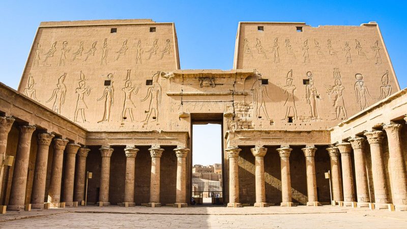 Explore the historic grandeur of ancient Egyptian ruins with towering columns and intricate carvings.