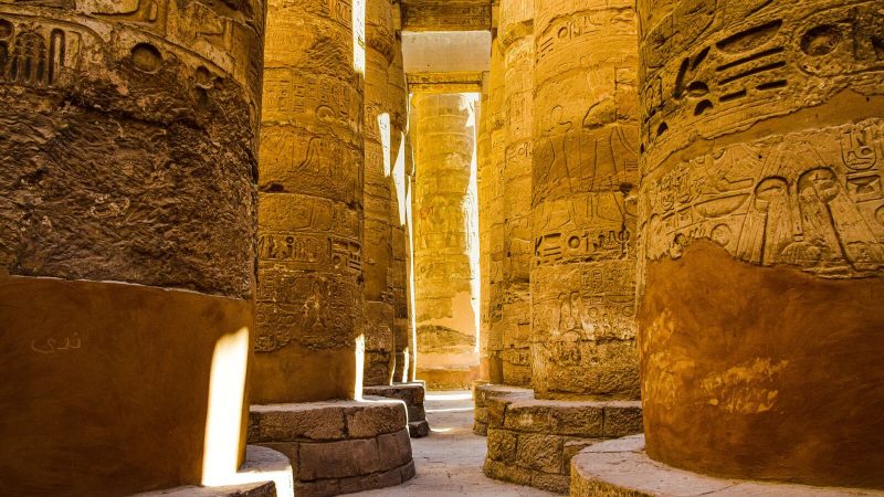 Sunlit ancient columns in the historic Karnak Temple Complex in Luxor, Egypt.