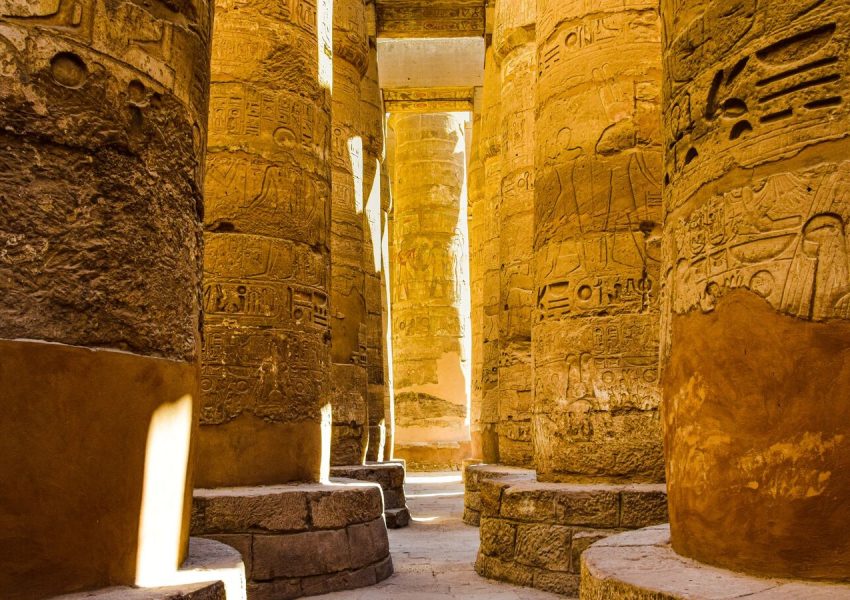 Sunlit ancient columns in the historic Karnak Temple Complex in Luxor, Egypt.