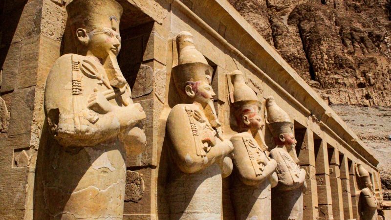 Row of ancient statues at the famous Hatshepsut Temple in Egypt.