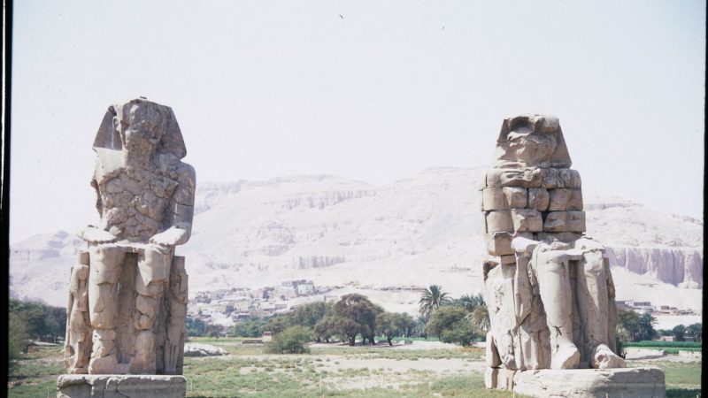 View of the Colossi of Memnon statues in Luxor, Egypt highlighting ancient Egyptian architecture.