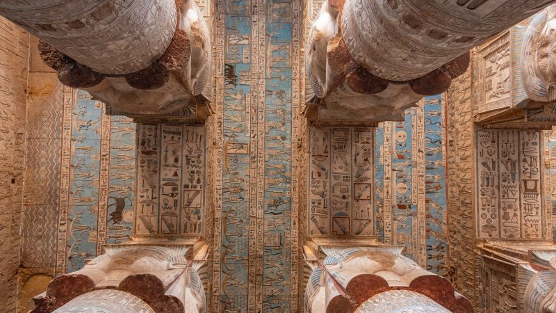 Detailed view of a richly decorated ancient Egyptian temple ceiling and columns.