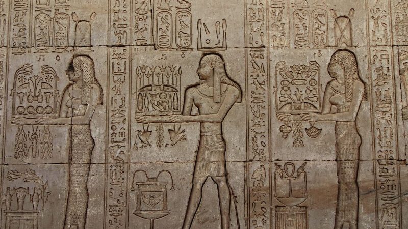 Detailed stone carvings of Egyptian hieroglyphs on the walls of Dendera Temple, Egypt.