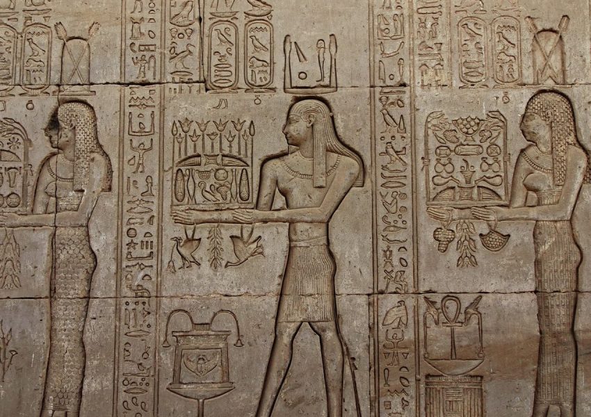 Detailed stone carvings of Egyptian hieroglyphs on the walls of Dendera Temple, Egypt.