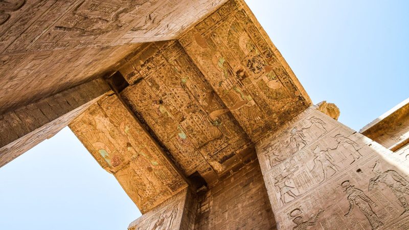 View of detailed carvings on an ancient Egyptian temple ceiling, showcasing historic art.
