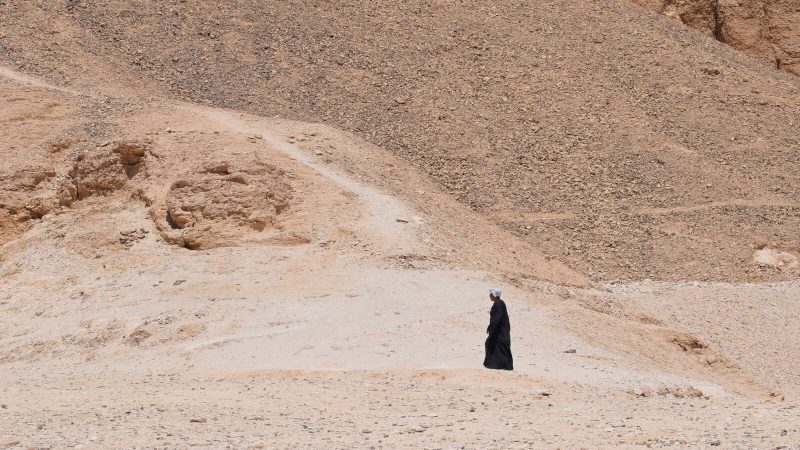 Desolate desert scene with a lone figure in Luxor, Egypt.