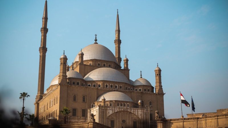 Explore the architectural beauty of the historic mosque in Cairo, featuring majestic domes and minarets.