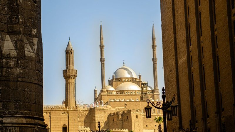 A stunning view of a mosque in Cairo featuring elegant minarets and a dome roof.