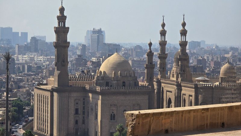A view of historic mosques and Cairo's skyline, showcasing traditional Islamic architecture.