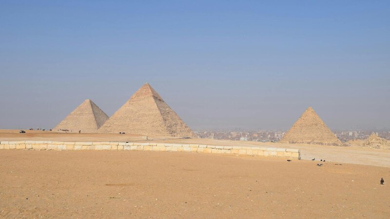 Breathtaking landscape of the Giza Pyramids under a clear blue sky in Cairo, Egypt.