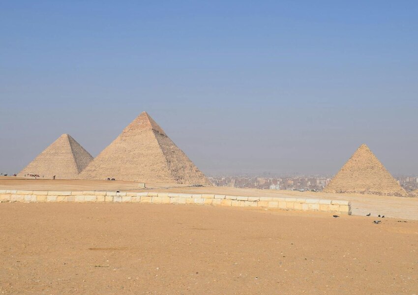 Breathtaking landscape of the Giza Pyramids under a clear blue sky in Cairo, Egypt.