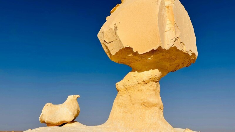 Sculptural rock formations under a clear blue sky in the White Desert, Egypt.
