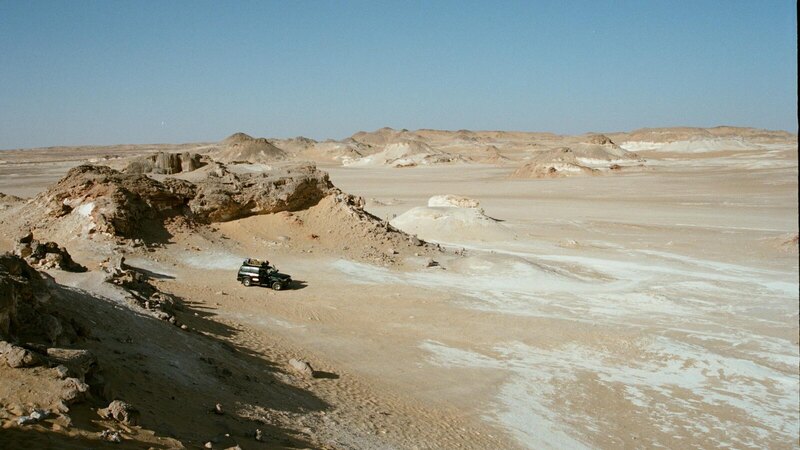 Explore the arid landscape of Farafra Desert with an off-road vehicle.