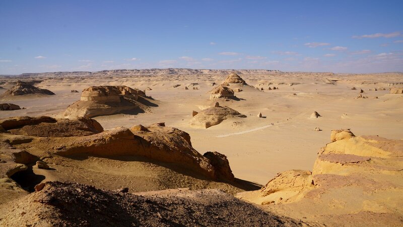 A breathtaking view of the Egyptian desert with unique rock formations under a bright clear sky.