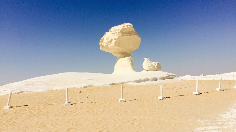 A striking rock formation in Egypt's White Desert under a blue sky.