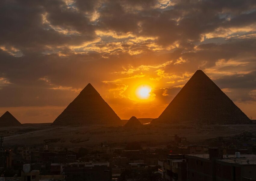 Silhouette of the Giza pyramids at sunset, capturing dramatic skies and ancient wonder.