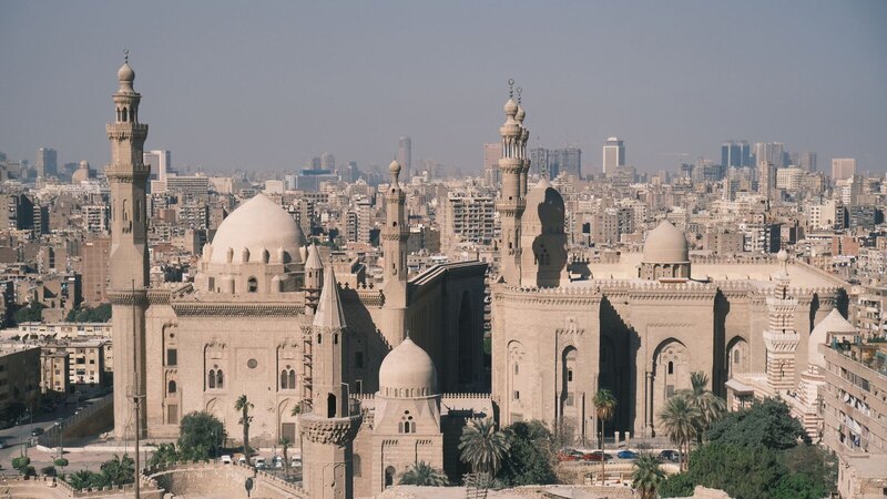 Scenic aerial view of Cairo with the iconic Mosque-Madrassa of Sultan Hassan and city skyline.