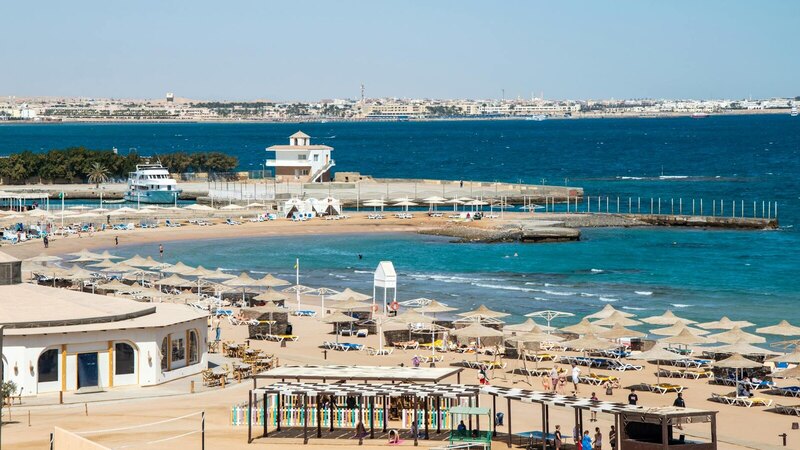 Aerial view of vibrant beach resort with umbrellas and blue sea.