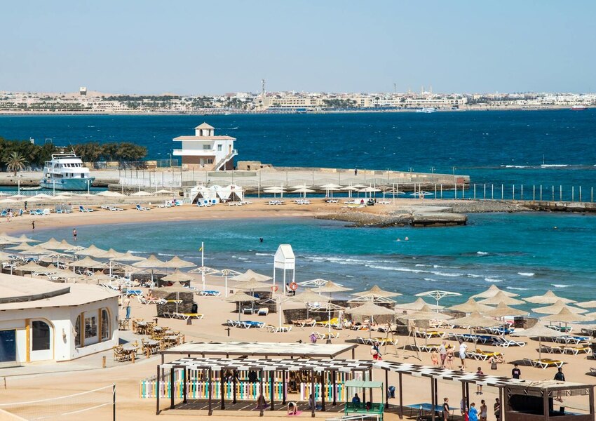 Aerial view of vibrant beach resort with umbrellas and blue sea.