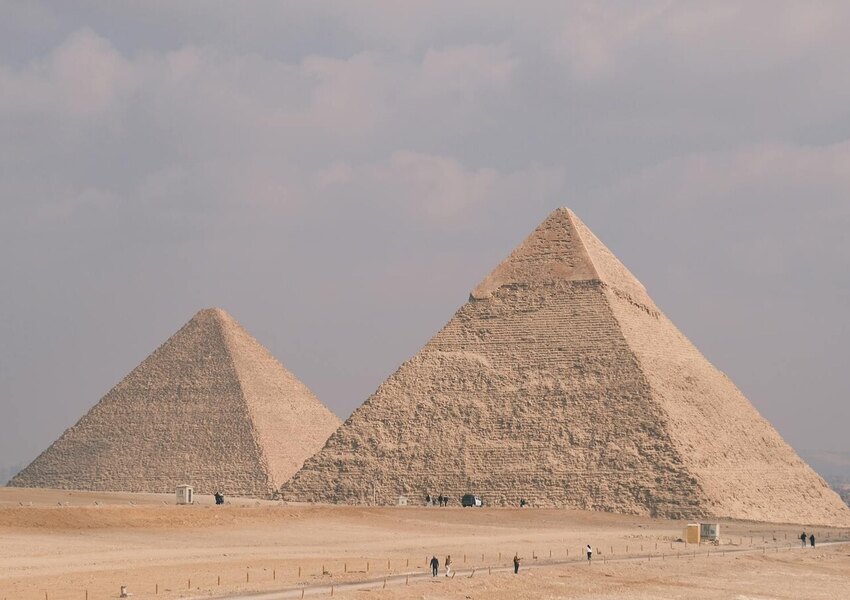 Stunning photo of the Great Pyramids of Giza under a cloudy sky, showcasing Egypt's ancient architecture.