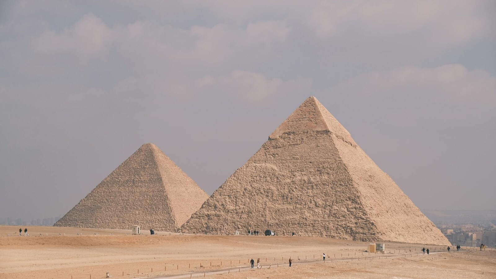 Stunning photo of the Great Pyramids of Giza under a cloudy sky, showcasing Egypt's ancient architecture.