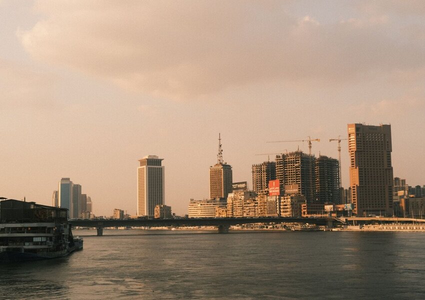 A scenic view of Cairo's skyline along the Nile River at sunset, capturing the city's modern architecture.